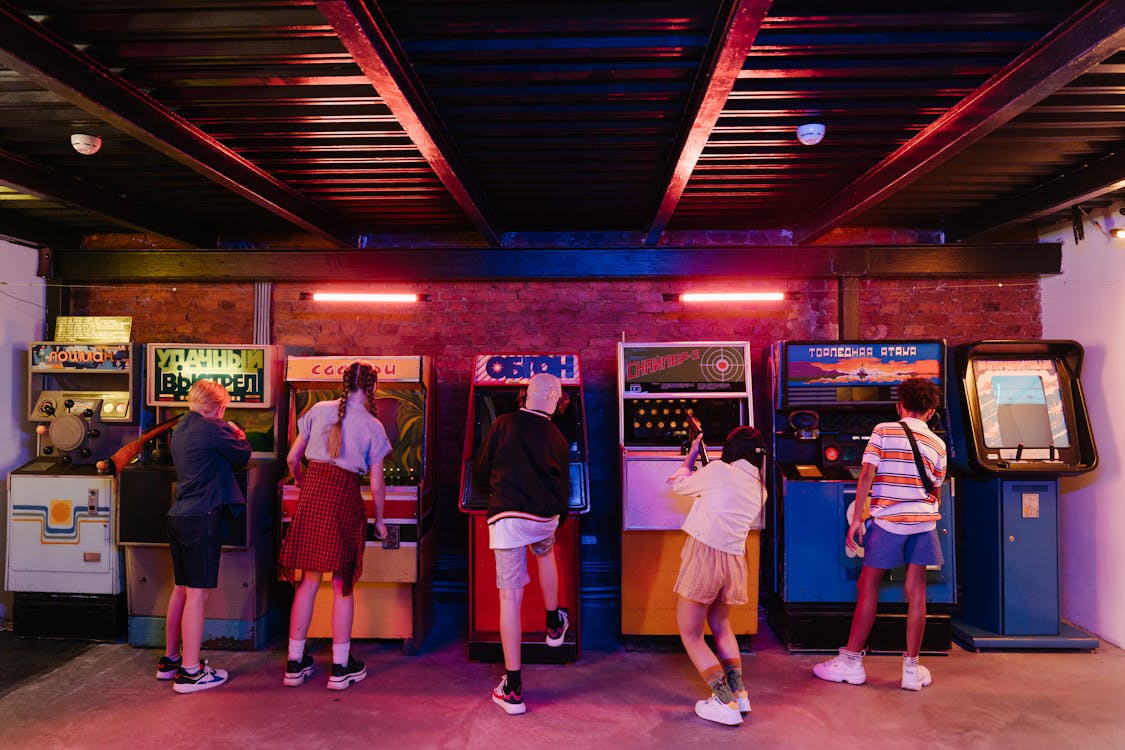 People playing classic arcade games